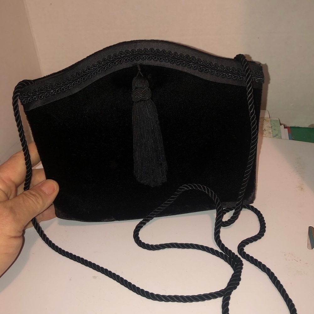 Black velvet like Clutch with Crescent Shape-tassel in front and cord strap.